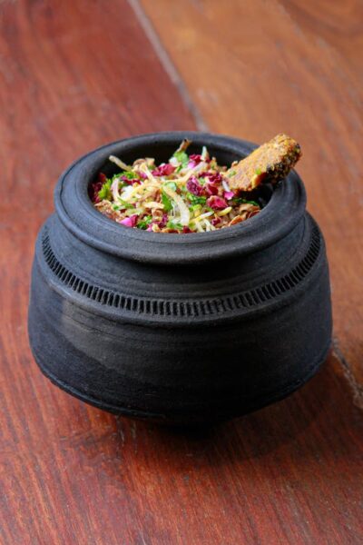 Authentic Indian biryani served in a rustic black clay pot on a wooden table.