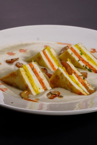 Delicious paneer dish with layered curry and cashew garnish, perfect for Indian cuisine lovers.